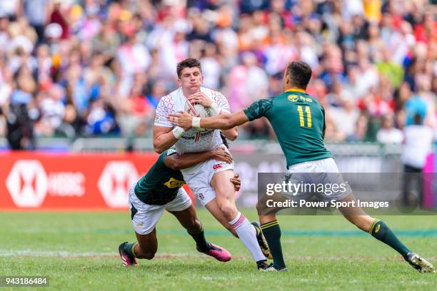 Stedman Gans and Muller du Plessis of South Africa put a tackle of Ben Howard of England during the HSBC Hong Kong Sevens 2018 match between South...