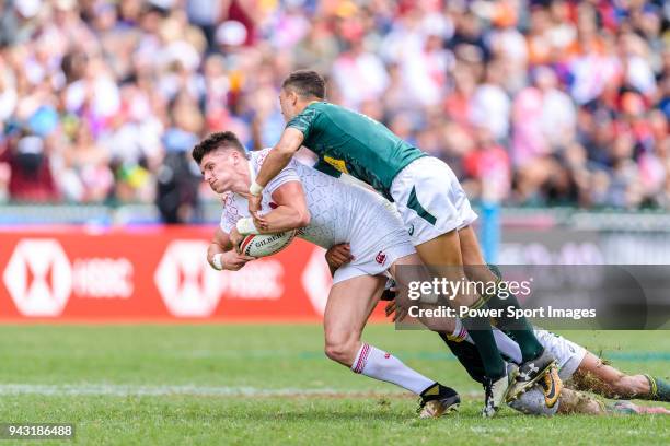 Stedman Gans and Muller du Plessis of South Africa put a tackle of Ben Howard of England during the HSBC Hong Kong Sevens 2018 match between South...