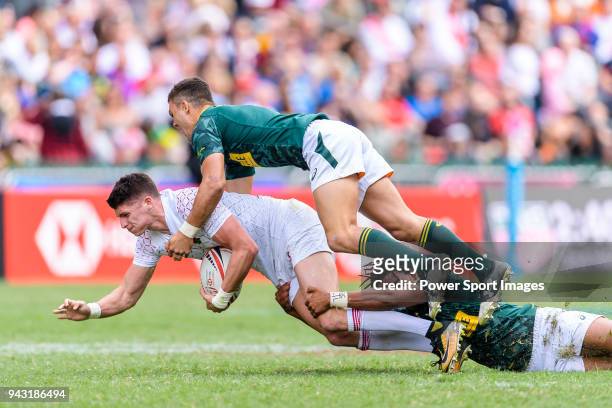 Stedman Gans and Muller du Plessis of South Africa put a tackle of Ben Howard of England during the HSBC Hong Kong Sevens 2018 match between South...