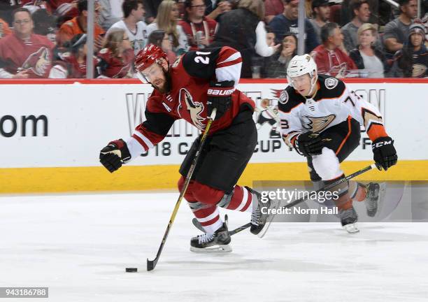 Derek Stepan of the Arizona Coyotes advances the puck up ice ahead of Andy Welinski of the Anaheim Ducks during the third period at Gila River Arena...