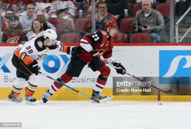 Oliver Ekman-Larsson of the Arizona Coyotes advances the puck up ice as Derek Grant of the Anaheim Ducks defends during the third period at Gila...