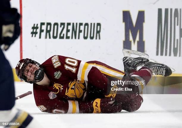 Kobe Roth of the Minnesota-Duluth Bulldogs is on the ice in pain after a hit by Justin Wade of the Notre Dame Fighting Irish in the first perod...