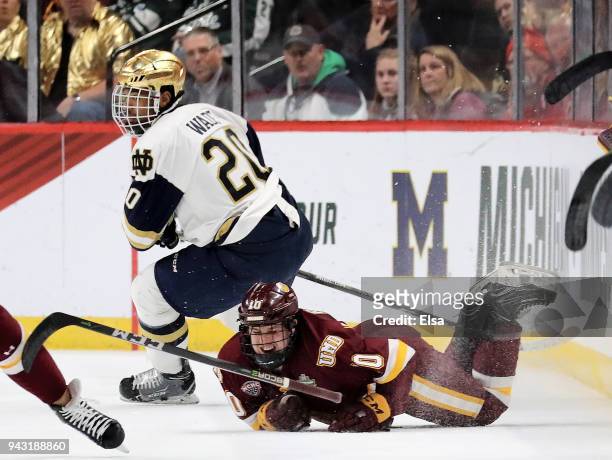 Kobe Roth of the Minnesota-Duluth Bulldogs is on the ice in pain after a hit by Justin Wade of the Notre Dame Fighting Irish in the first perod...
