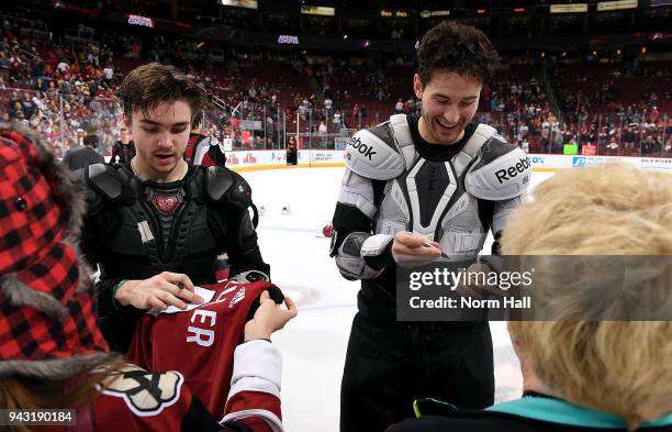 Clayton Keller and Brendan Perlini of the Arizona Coyotes sign their jerseys for fans as part of Fan Appreciation Night - Jerseys off their Back...