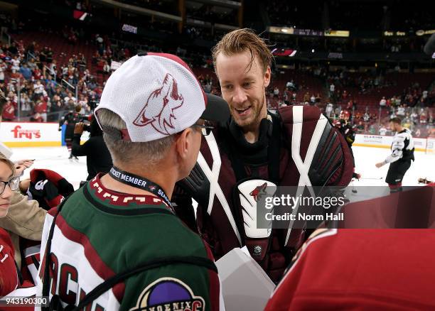 Goalie Antti Raanta of the Arizona Coyotes gives a fan his jersey as part of the Fan Appreciation Night - Jerseys off their Back event following the...