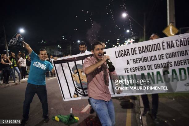 Opponents of Brazilian former president Luiz Inacio Lula da Silva celebrate his arrest in the streets around the Federal Police headquarters where he...