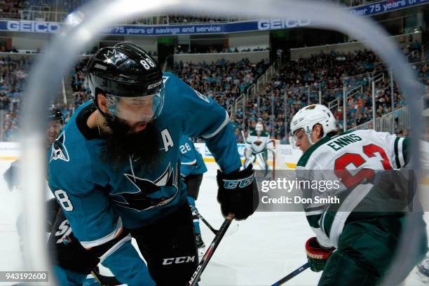 Brent Burns of the San Jose Sharks and Tyler Ennis of the Minnesota Wild battle in the corner at SAP Center on April 7, 2018 in San Jose, California.