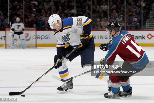 Colton Parayko of the St Louis Blues advances the puck against Blake Comeau of the Colorado Avalanche at the Pepsi Center on April 7, 2018 in Denver,...