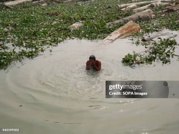 Vendor taking bath in the floating timber market. In the delta of rivers Ganga , Brahmaputra and Meghna people live on the water. Area around the...