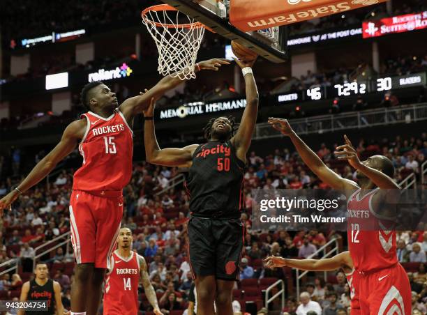 Caleb Swanigan of the Portland Trail Blazers goes up for a shot defended by Clint Capela of the Houston Rockets and Luc Mbah a Moute in the first...