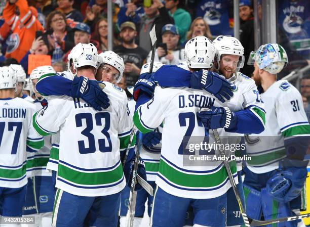 Henrik Sedin, Daniel Sedin, Alexander Edler and Bo Horvat of the Vancouver Canucks celebrate after the final game of the season against the Edmonton...