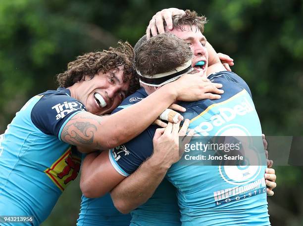 Kevin Proctor, Jarrod Wallace and Jai Arrow of the Titans celebrate the winning try during the round five NRL match between the Gold Coast Titans and...