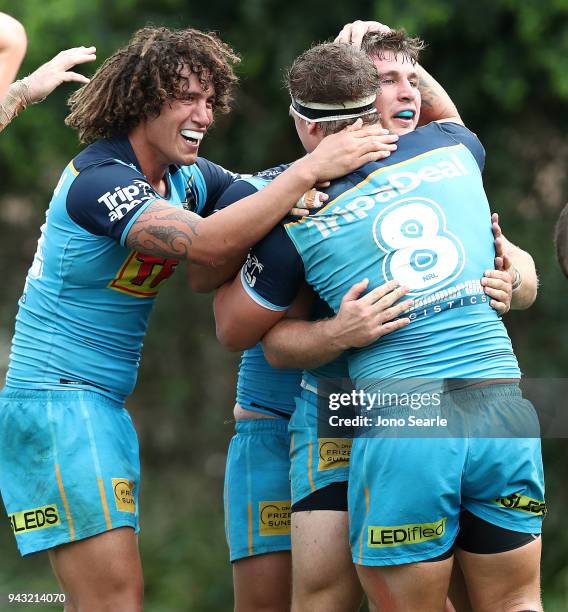 Kevin Proctor, Jarrod Wallace and Jai Arrow of the Titans celebrate the winning try during the round five NRL match between the Gold Coast Titans and...