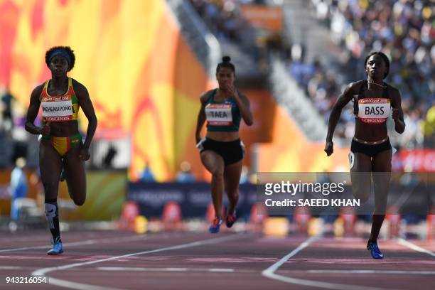 Ghanas Gemma Acheampong, Cook Islands Patricia Nooroa Taea and The Gambias Gina Bass compete in the athletic's women's 100m heats during the 2018...