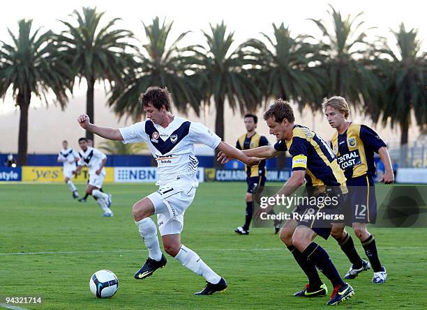 Robbie Kruse of the Victory is challenged by Alex Wilkinson of the Mariners during the round 18 A-League match between the Central Coast Mariners and...