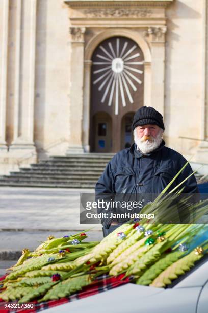 ragusa, sicily: senior vendor sells woven palm fronds - palm sunday stock pictures, royalty-free photos & images