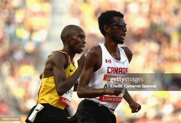 Mohammed Ahmed of Canada and Joshua Kiprui Cheptegei of Uganda lead the pack in the Men's 5000 metres final on day four of the Gold Coast 2018...