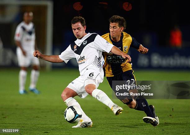 Lee Broxham of the Victory is tackled by Nicky Travis of the Mariners during the round 18 A-League match between the Central Coast Mariners and the...