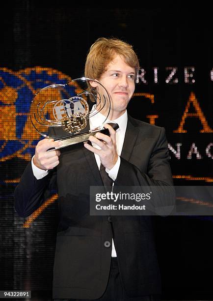 In this handout image provided by FIA, driver Sebastian Vettel of Germany poses with his FIA trophy during the 2009 FIA Gala Prize Giving Ceremony...