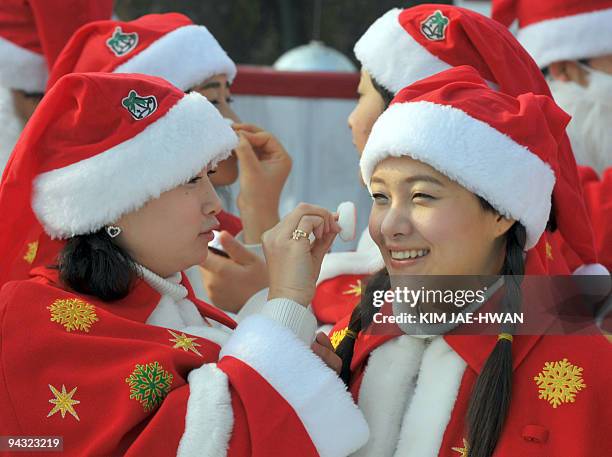 South Korean women wearing Santa Claus oufits apply makeup on the skating rinkon the skating rink of the Everend amusement park in Yongin south of...