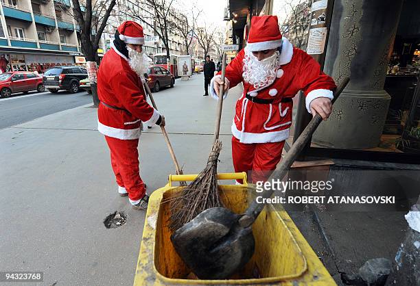 Two sanitary workers dressed as Santa Claus collect garbage in the centre of Skopje on December 22, 2008. AFP PHOTO / ROBERT ATANASOVSKI