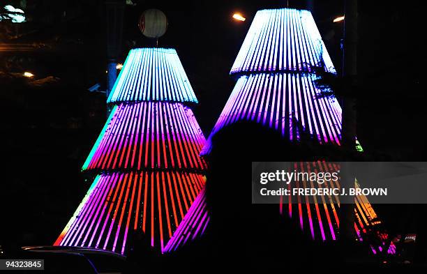 Man walks past illuminated tree-like structures decorating an office building in Beijing on November 19, 2008. While the religious celebration of the...
