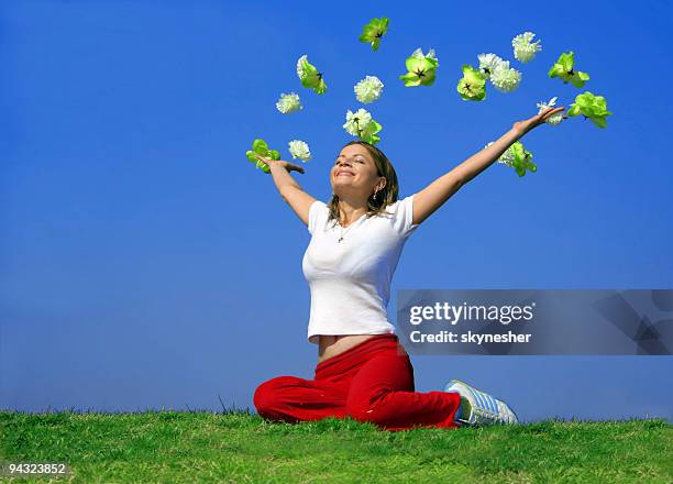 happy young woman outdoor with flying flowers - throwing flowers stock pictures, royalty-free photos & images