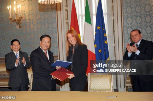 Italian Tourism Minister Michela Brambilla and Vietnamese Information and Cooperation Minister Le Doan Hop exchange documents after signing a...