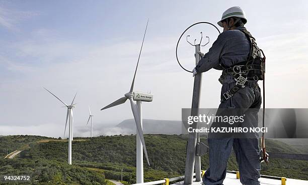 Japan-environment-climate-warming, by Patrice Novotny Ryo Nagasawa, chief mechanic of wind-power farm Eurus Energy Japan Corporation works on top of...
