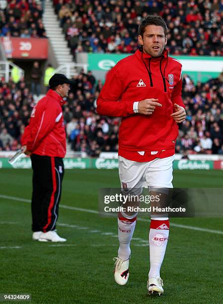 James Beattie of Stoke warms up as manager Tony Pulis watches the game during the Barclays Premier League match between Stoke City and Wigan Athletic...