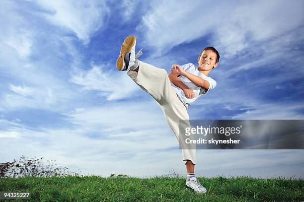 karate boy on meadow - martial arts kid stock pictures, royalty-free photos & images