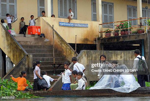 Cambodian students climb up to their school from a boat at a flooded village in Kandal province, some 25 kilometres east of Phnom Penh, on October...