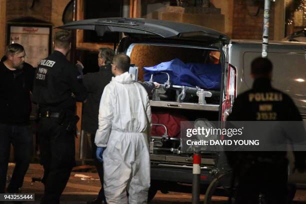 Body bag on a stretcher is being loaded into a van as investigators work at the square where a man rammed his car into a crowd killing two and...
