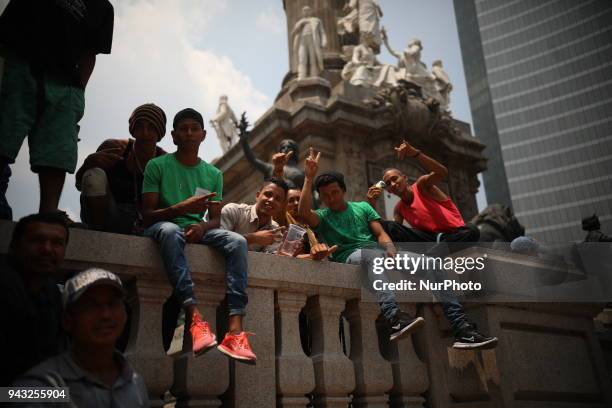 Group of central american, part of the the annual Stations of the Cross caravan march for migrants' rights, sit on the steps of the Angel of...