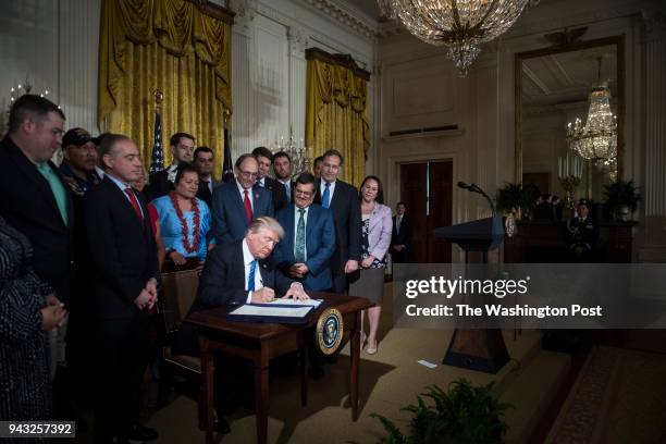 President Donald Trump, with Secretary of Veterans Affairs David Shulkin by his side, signs the "Department of Veterans Affairs Accountability and...