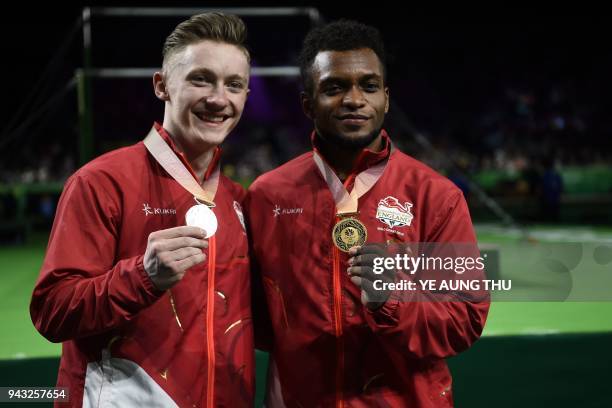 Gold medallist England's Courtney Tulloch poses with silver medallist and compatriot Nile Wilson after the men's rings final artistic gymnastics...