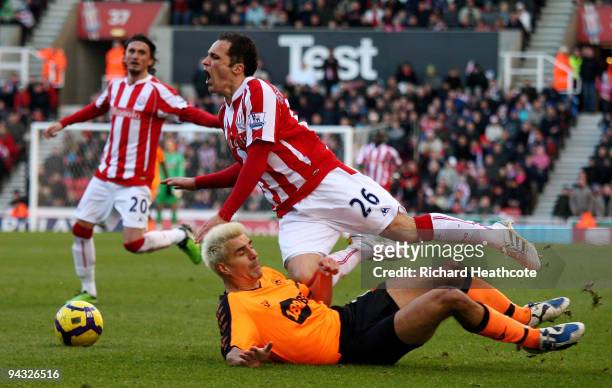 Matthew Etherington of Stoke is brought down by the challenge of Paul Scharner of Wigan during the Barclays Premier League match between Stoke City...