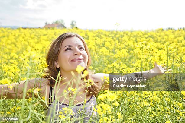feliz chica en un campo amarillo. - flower arm fotografías e imágenes de stock
