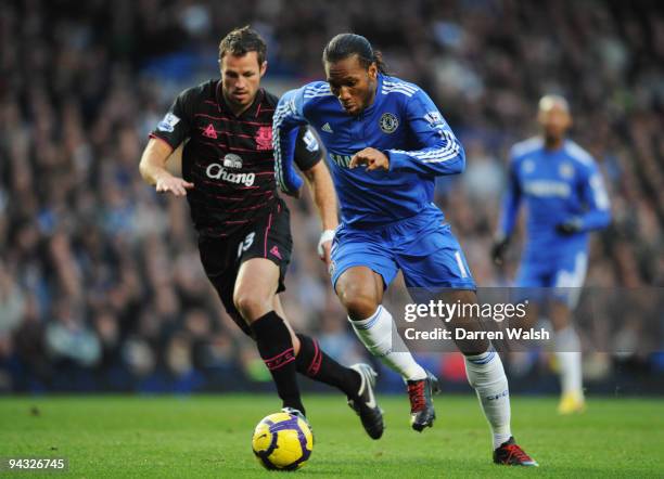 Didier Drogba of Chelsea holds off the challenge of Lucas Neill of Everton during the Barclays Premier League match between Chelsea and Everton at...