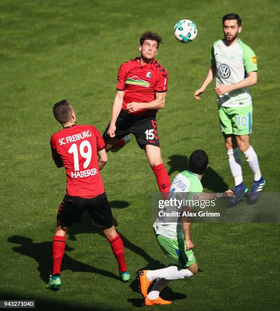 Pascal Stenzel and Janik Haberer of Freiburg are challenged by William and Yunus Malli of Wolfsburg during the Bundesliga match between Sport-Club...
