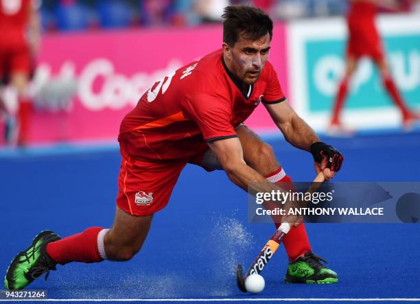 Adam Dixon of England hits the ball during the men's field hockey match between Pakistan and England at the 2018 Gold Coast Commonwealth Games on the...