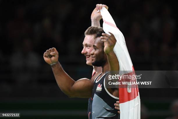 England's Courtney Tulloch poses with teammate Nile Wilson after they came in first and second respectively in the men's rings final artistic...