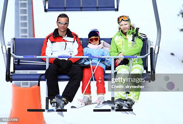 family on chairlift at ski resort. - woman on ski lift stock pictures, royalty-free photos & images