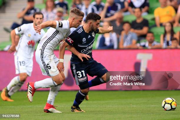 Christian Theoharous of Melbourne Victory and Dylan Fox of Wellington Phoenix both fight for the ball during the round 26 A-League match between the...