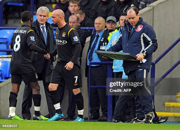 Manchester City's Welsh manager Mark Hughes speaks to English midfielder Shaun Wright-Phillips after he was substituted during the English Premier...