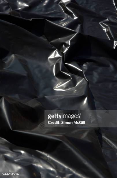 wrinkled black plastic sheeting - hochglanz stock-fotos und bilder