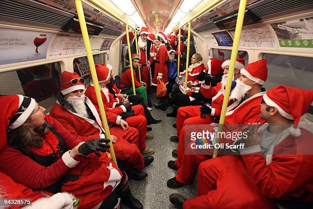 Londoners dressed in Santa Claus costumes ride the underground as they participate in 'SantaCon', a Santa-themed pub crawl across the capital on...