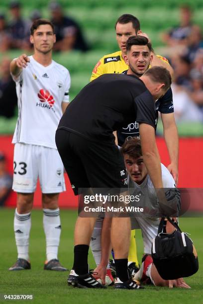 Dylan Fox of Wellington Phoenix gets up off the ground as Christian Theoharous of Melbourne Victory looks worried for what might come after colliding...