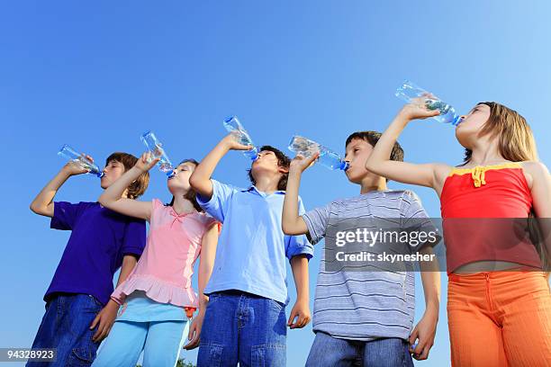 cinco hijos de agua potable de frascos. - niño-tomando-agua fotografías e imágenes de stock
