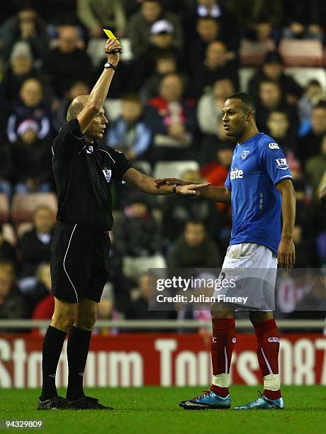 Referee, Steve Bennett shows Younes Kaboul of Portsmouth his first yellow card during the Barclays Premier League match between Sunderland and...